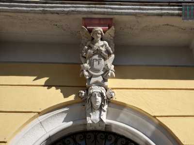 Foto 12. Il portone d�ingresso, in ferro, � racchiuso da una cornice di pietra sulla cui chiave di volta spicca una testa femminile con drappeggi e fiori (foto di Antonio Caradonna)
